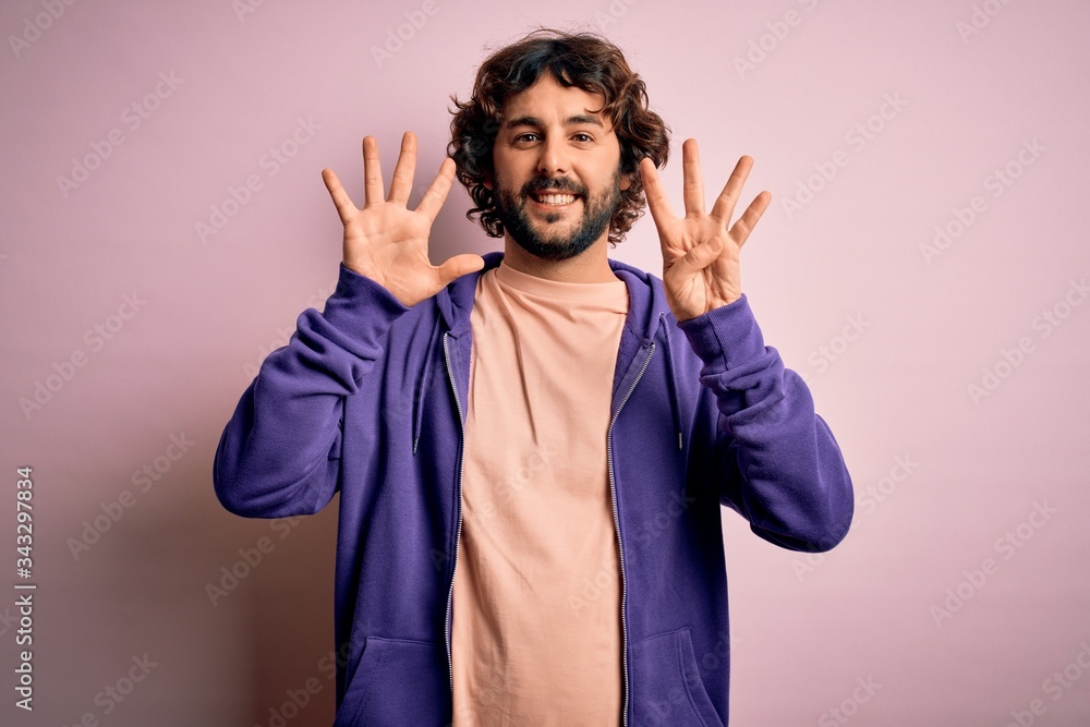 Young handsome sporty man with beard wearing casual sweatshirt over pink background showing and pointing up with fingers number nine while smiling confident and happy. Young handsome sporty man with beard wearing casual sweatshirt over pink background showing and pointing up with fingers number nine while smiling confident and happy.
