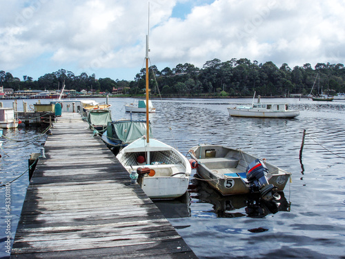 Boats moored at an old wooden jetty in Strahan Harbour