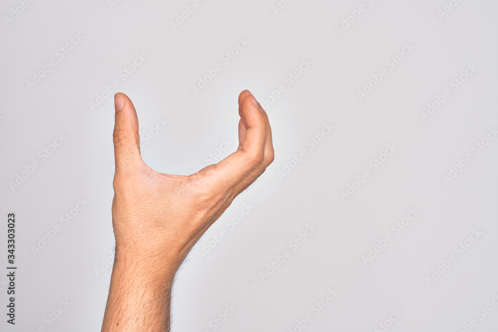 Hand of caucasian young man showing fingers over isolated white background picking and taking invisible thing, holding object with fingers showing space Hand of caucasian young man showing fingers over isolated white background picking and taking invisible thing, holding object with fingers showing space