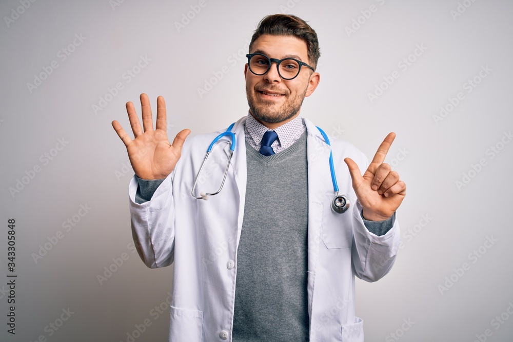 Young doctor man with blue eyes wearing medical coat and stethoscope over isolated background showing and pointing up with fingers number seven while smiling confident and happy. Young doctor man with blue eyes wearing medical coat and stethoscope over isolated background showing and pointing up with fingers number seven while smiling confident and happy.
