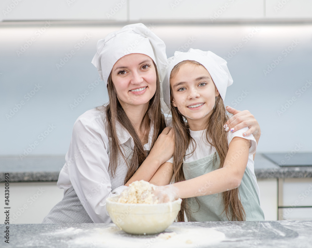 Mother and her daughter cook in the kitchen at home Mother and her daughter cook in the kitchen at home