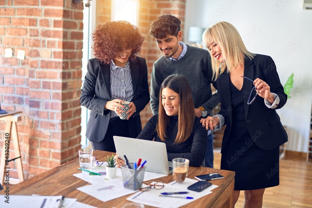 Group of business workers smiling happy and confident. Working together with smile on face using laptop at the office Group of business workers smiling happy and confident. Working together with smile on face using laptop at the office