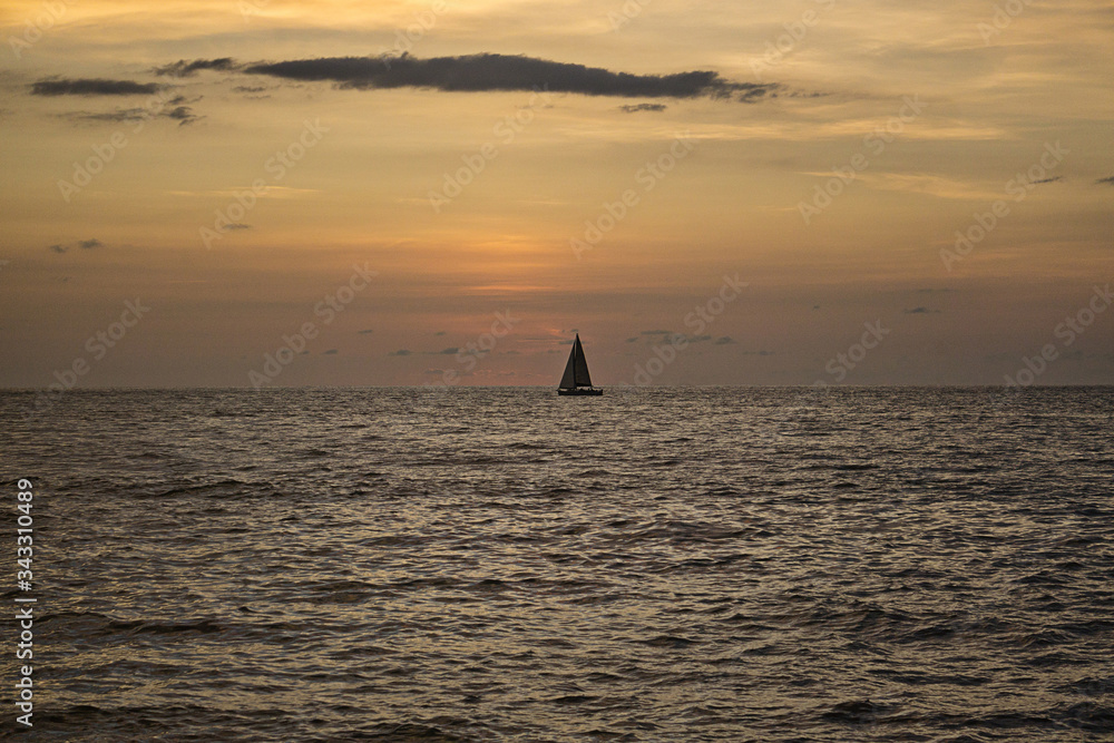 Atardecer en el mar de Mazatlan cielo despejado con velero o barco y barco de vela