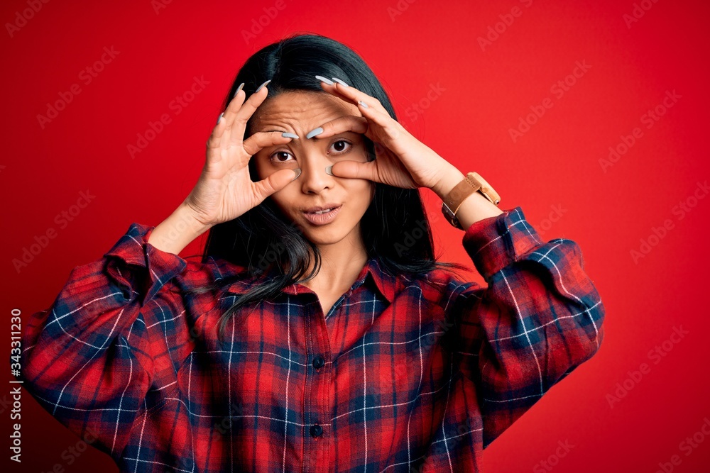 Young beautiful chinese woman wearing casual shirt over isolated red background Trying to open eyes with fingers, sleepy and tired for morning fatigue Young beautiful chinese woman wearing casual shirt over isolated red background Trying to open eyes with fingers, sleepy and tired for morning fatigue