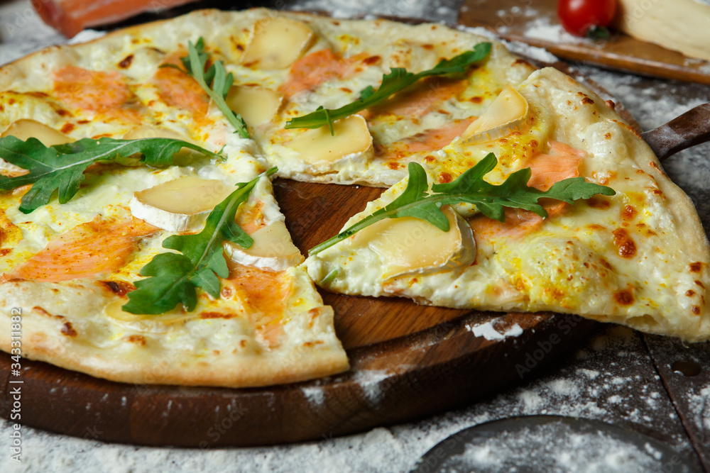 Italian salmon pizza with brie cheese and arugula