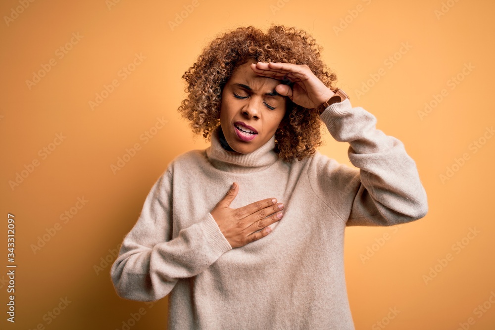 Young beautiful african american woman wearing turtleneck sweater over yellow background Touching forehead for illness and fever, flu and cold, virus sick Young beautiful african american woman wearing turtleneck sweater over yellow background Touching forehead for illness and fever, flu and cold, virus sick