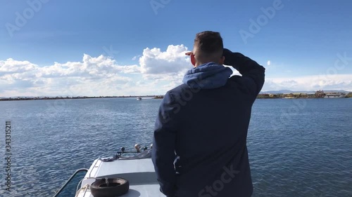 Young guy traveling to Uros Islands, in Perú. Boy sighting the islands of Uros from a boat. Chico navegando hacia las islas flotantes de Uros. photo