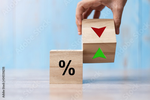 business man Hand change wood cube block with percentage to UP and Down arrow symbol icon. Interest rate, stocks, financial, ranking, mortgage rates and Cut loss concept