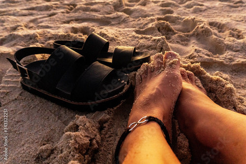 Obraz na plátně Female foot with sandals on the sand