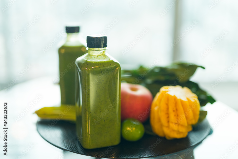 Two bottles of healthy green smoothie mixed with fruits and vegetables Two bottles of healthy green smoothie mixed with fruits and vegetables