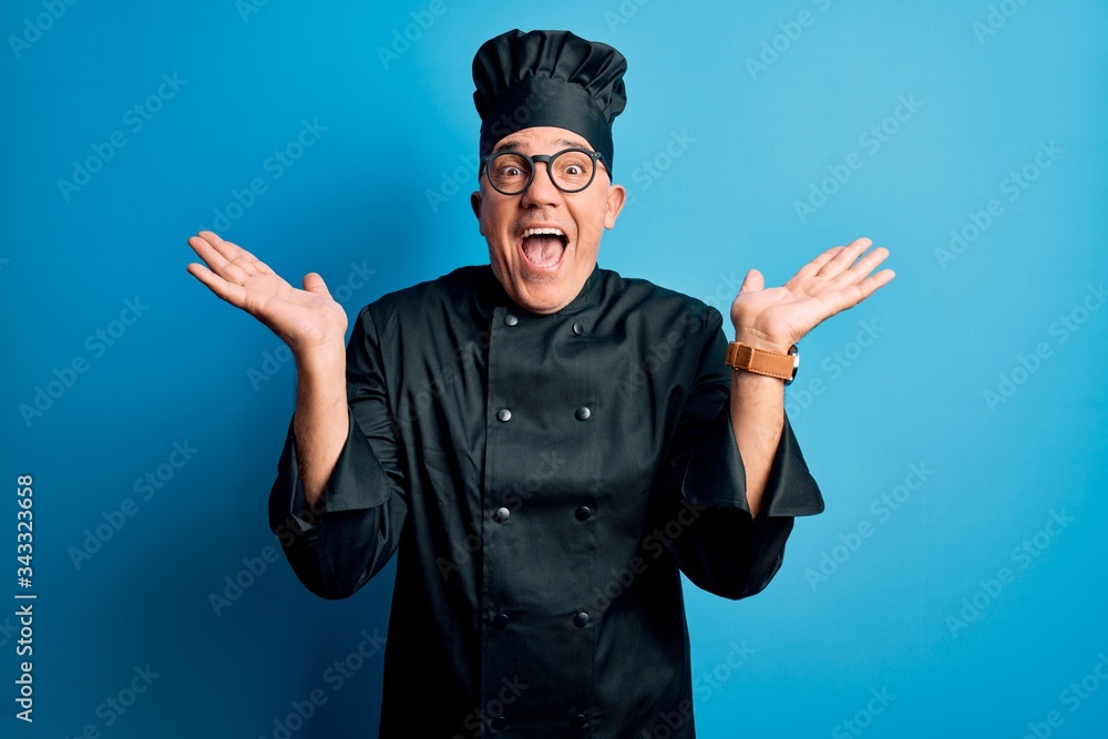 Middle age handsome grey-haired chef man wearing cooker uniform and hat celebrating crazy and amazed for success with arms raised and open eyes screaming excited. Winner concept Middle age handsome grey-haired chef man wearing cooker uniform and hat celebrating crazy and amazed for success with arms raised and open eyes screaming excited. Winner concept
