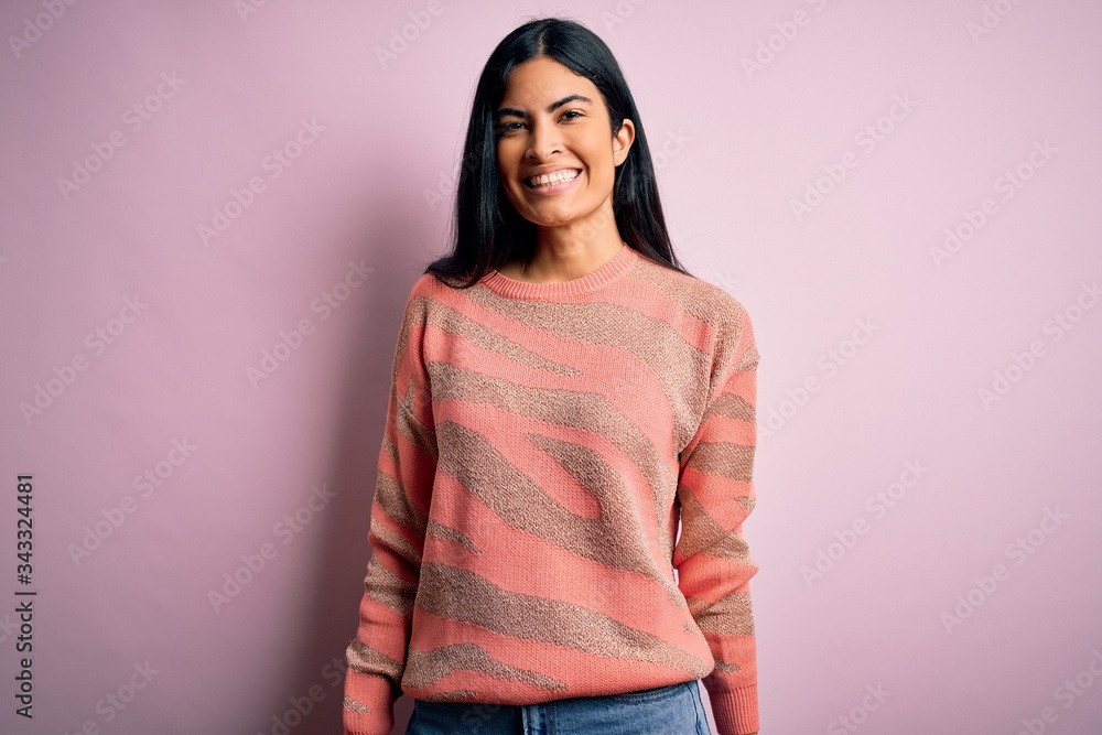 Young beautiful hispanic fashion woman wearing animal print sweater over pink background with a happy and cool smile on face. Lucky person. Young beautiful hispanic fashion woman wearing animal print sweater over pink background with a happy and cool smile on face. Lucky person.