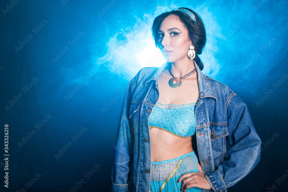 Obraz premium Magic, cosplay and fairy tale concept - Portrait of a young woman in the image of an Eastern fairy Princess on blue background.