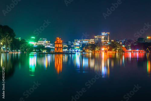 Night and long exposure skyline view of Hanoi, Vietnam buildings at Hoan Kiem Lake with light reflections © Patrick