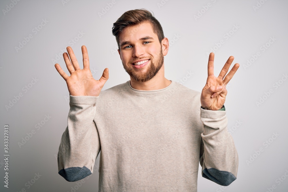 Young handsome blond man with beard and blue eyes wearing casual sweater showing and pointing up with fingers number eight while smiling confident and happy. Young handsome blond man with beard and blue eyes wearing casual sweater showing and pointing up with fingers number eight while smiling confident and happy.