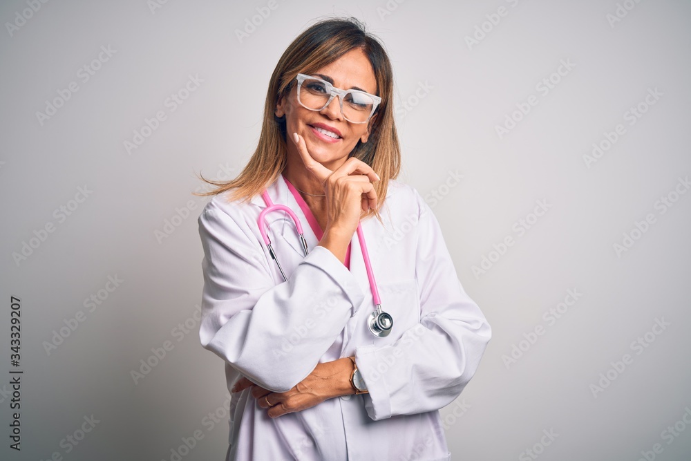 Middle age beautiful doctor woman wearing pink stethoscope over isolated white background looking confident at the camera with smile with crossed arms and hand raised on chin. Thinking positive.