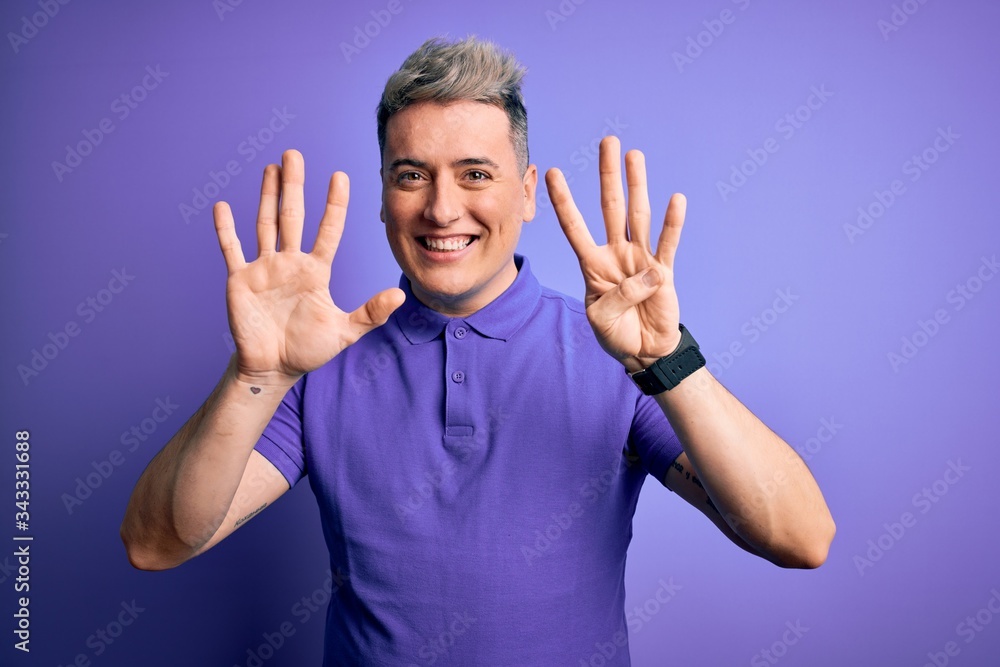 Young handsome modern man wearing casual purple t-shirt over isolated background showing and pointing up with fingers number nine while smiling confident and happy. Young handsome modern man wearing casual purple t-shirt over isolated background showing and pointing up with fingers number nine while smiling confident and happy.