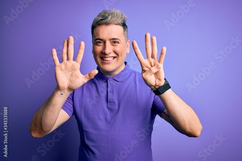 Young handsome modern man wearing casual purple t-shirt over isolated background showing and pointing up with fingers number nine while smiling confident and happy.