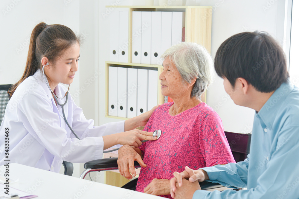 Obraz premium Asian female doctor checking senior patient's heartbeat by stethoscope at hospital
