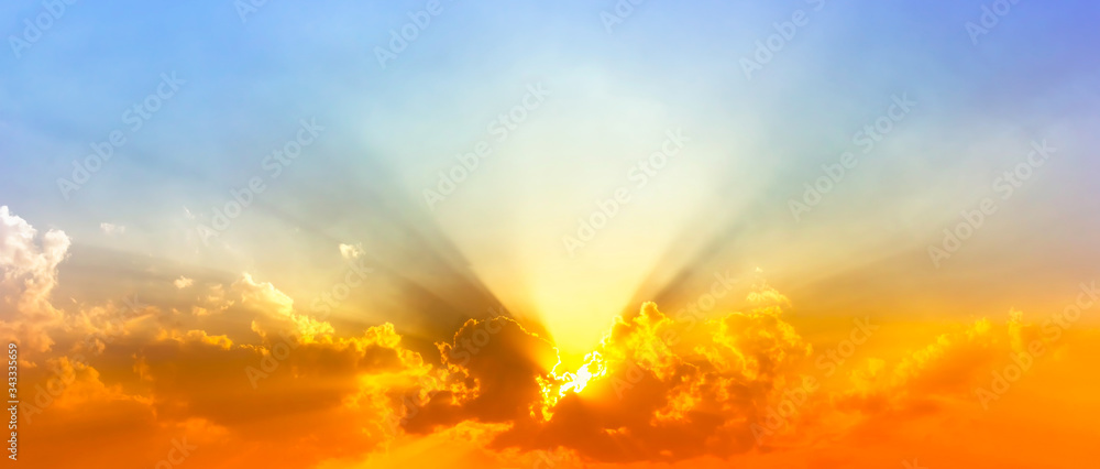 colorful sunshine light in blue sky with clouds and bright red orange and yellow color light