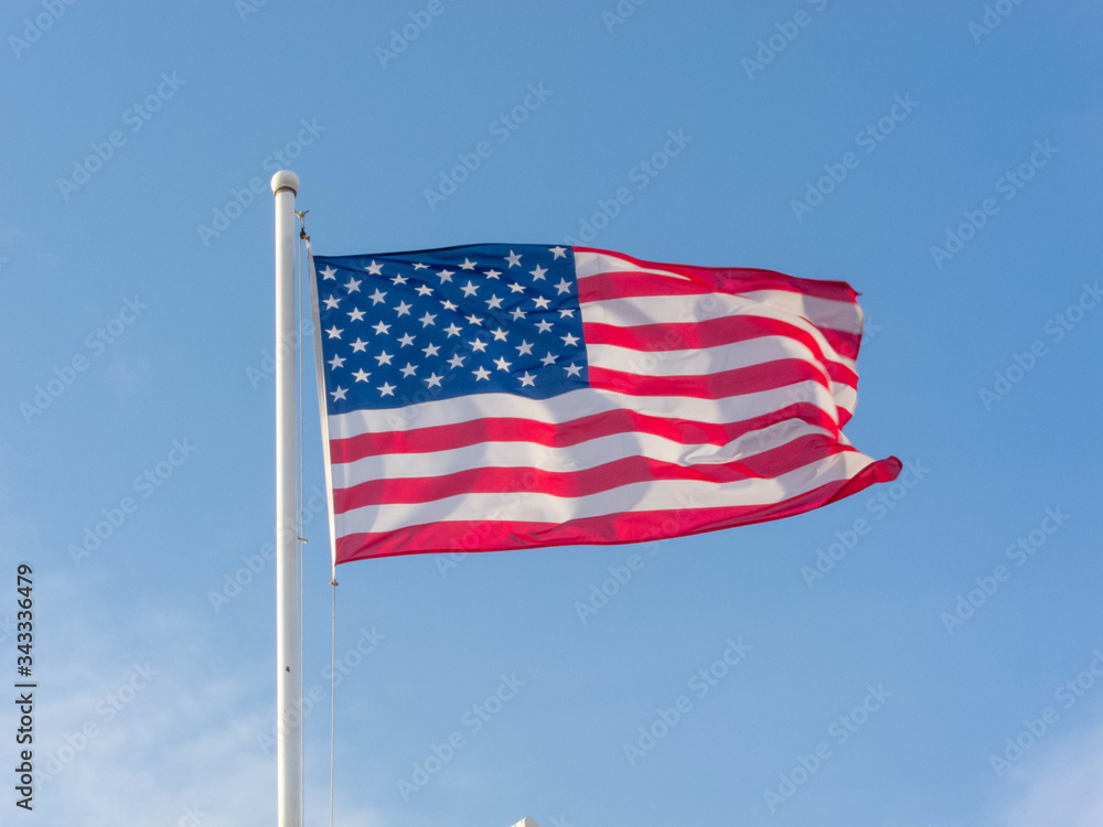 Flag of the United States on the blue sky.