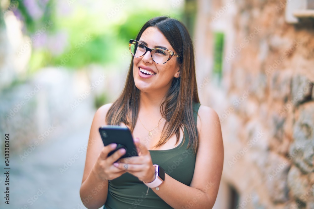 Young beautiful woman smiling happy and confident. Standing with smile on face using smartphone at the city Young beautiful woman smiling happy and confident. Standing with smile on face using smartphone at the city