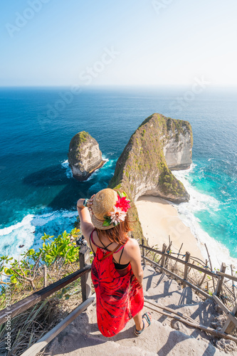 A woman traveller walking down to Kelingking beach in Nusa Penida island near Bali island in Indonesia