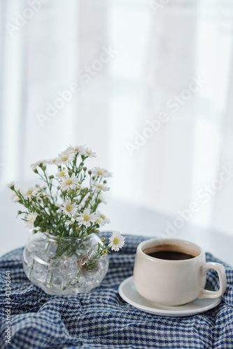 Wallpaper Mural Vase with blooming flowers and cup of tasty black coffee on table Torontodigital.ca