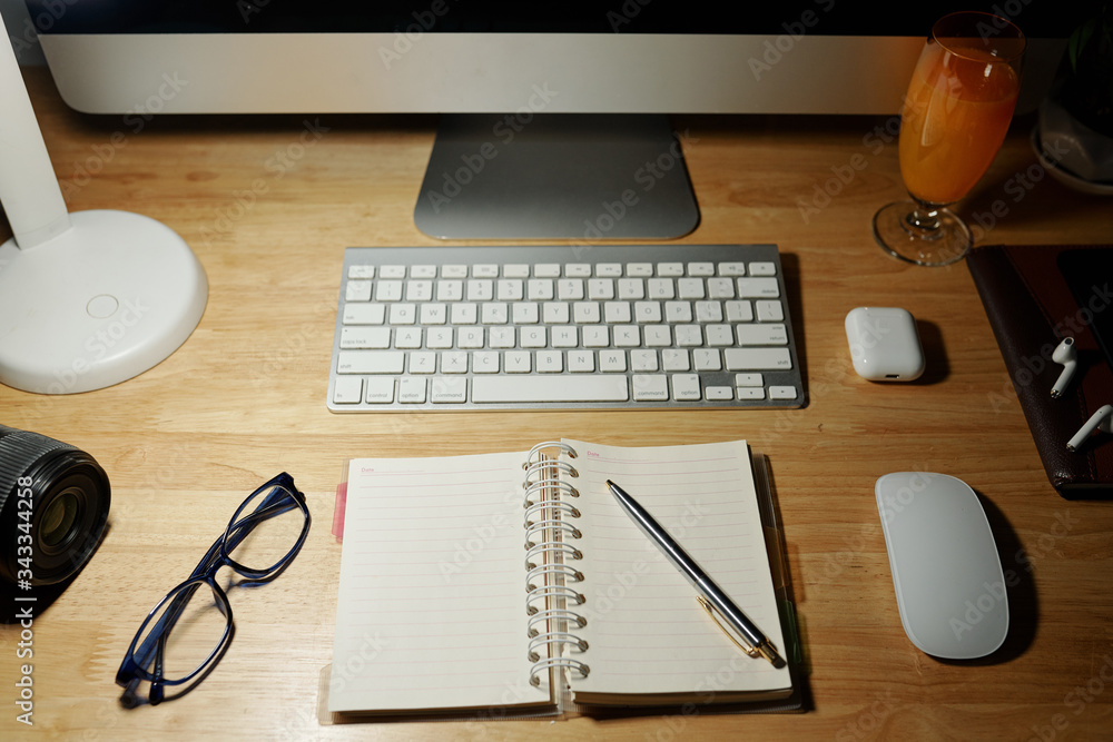 Opened planner, pen and glasses on home office desk during coronavirus pandemic Opened planner, pen and glasses on home office desk during coronavirus pandemic