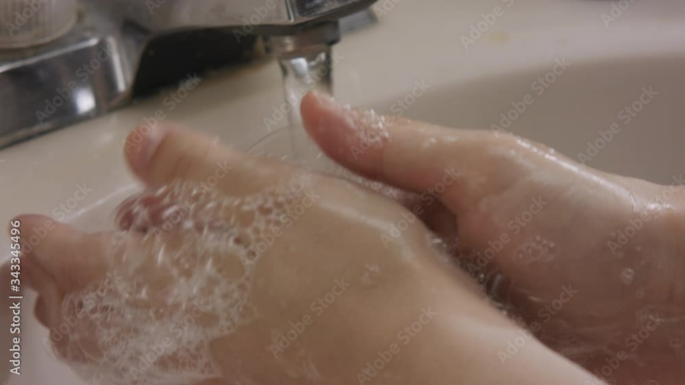 White female hands wash with soap foam and bubbles in slow motion close up shot. White female hands wash with soap foam and bubbles in slow motion close up shot.