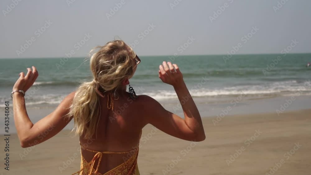 Girl dance on the beach. Beautiful young woman is dancing on the sea beach Girl dance on the beach. Beautiful young woman is dancing on the sea beach