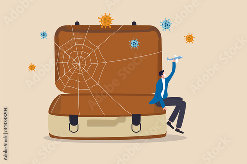 Trip cancelled, travel suspend all airports closed in Coronavirus COVID-19 outbreak crisis concept, sad man tourist sitting on empty travel bag, luggage holding toy airplane wait for travel the world