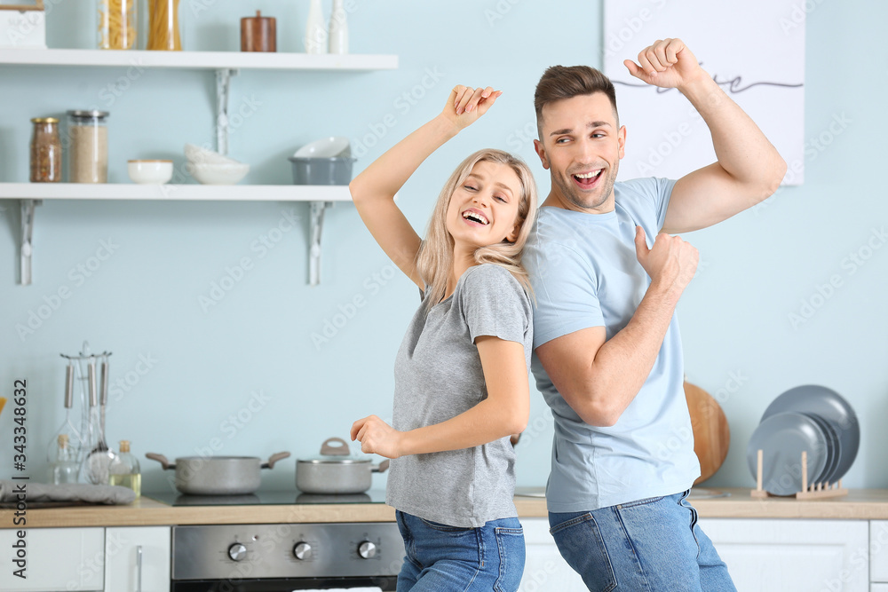 Happy dancing young couple in kitchen Happy dancing young couple in kitchen