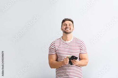 Happy man with purse on lig...