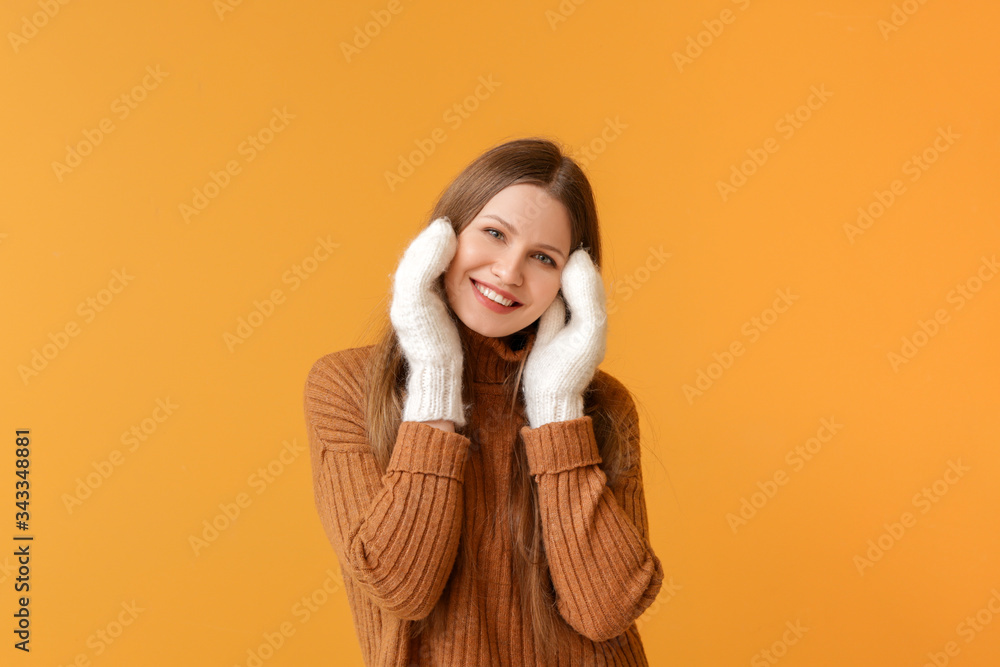 Beautiful young woman in warm sweater on color background Beautiful young woman in warm sweater on color background
