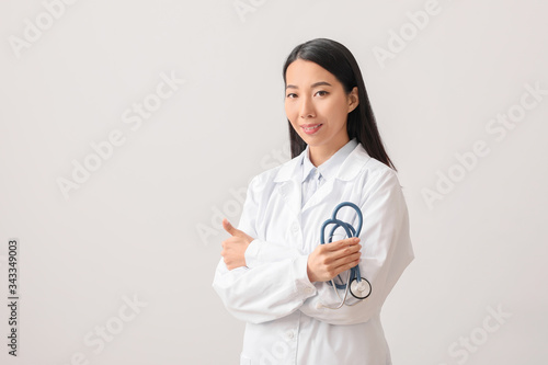 Asian Female Doctor with Stethoscope and Thumbs Up