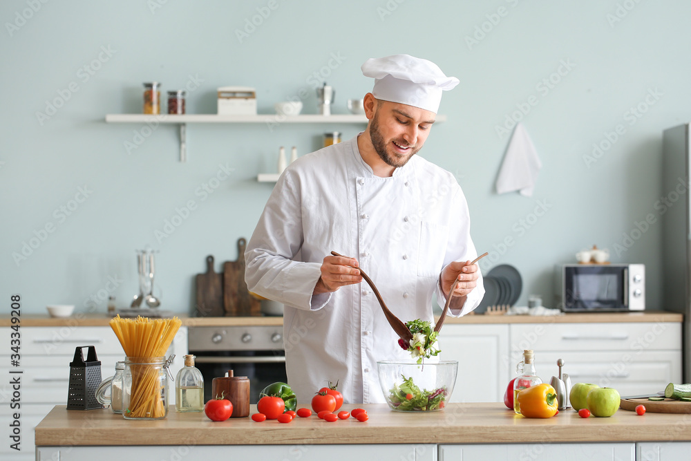 Handsome male chef cooking in kitchen Handsome male chef cooking in kitchen