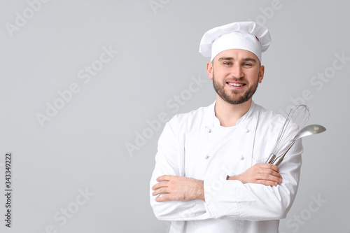 Handsome male chef on light...