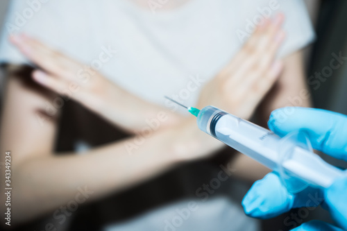 .Stop vaccinations. Say no to the coronavirus vaccines. A syringe in the doctor’s hand and a refusing patient says NO. Hand stop sign. Coronavirus vaccine covid-19 2019-ncov