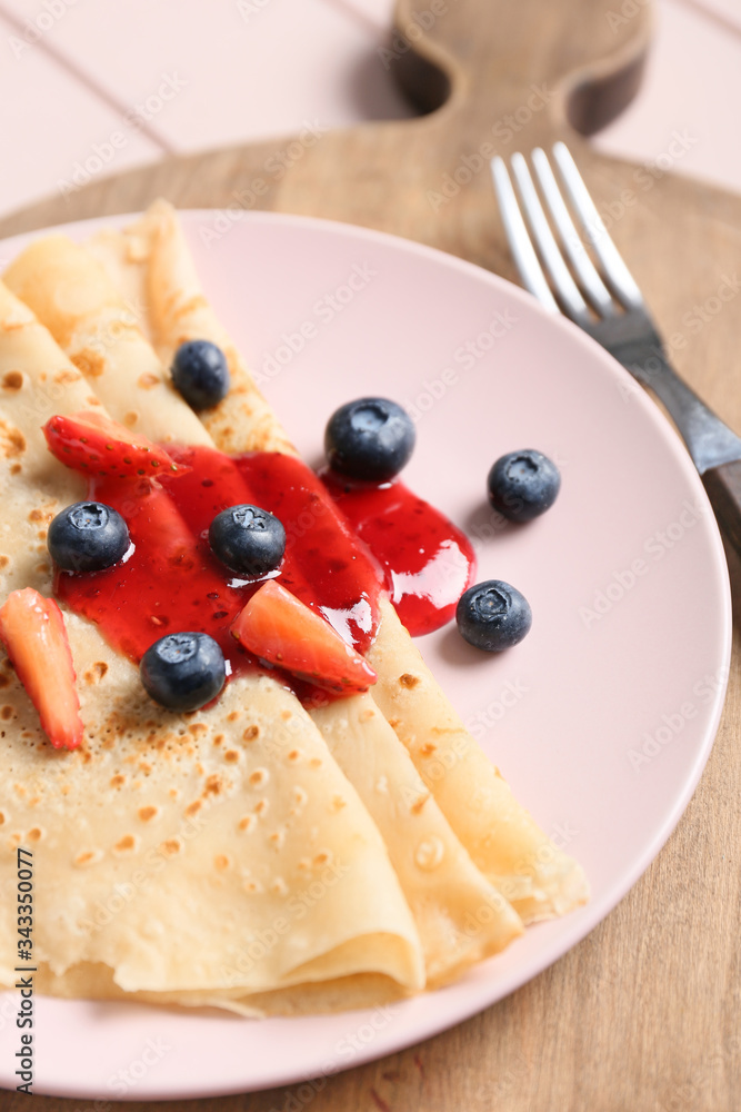 Plate with tasty blini and berries on table, closeup Plate with tasty blini and berries on table, closeup