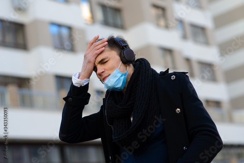 People with face mask. Concept with copy space. Portrait of adult man in quarantine of flu. Photo on the street in the city