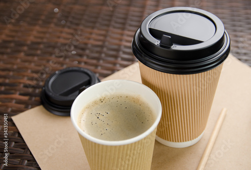 Two paper cups with coffee. one of them is open, the other with a lid