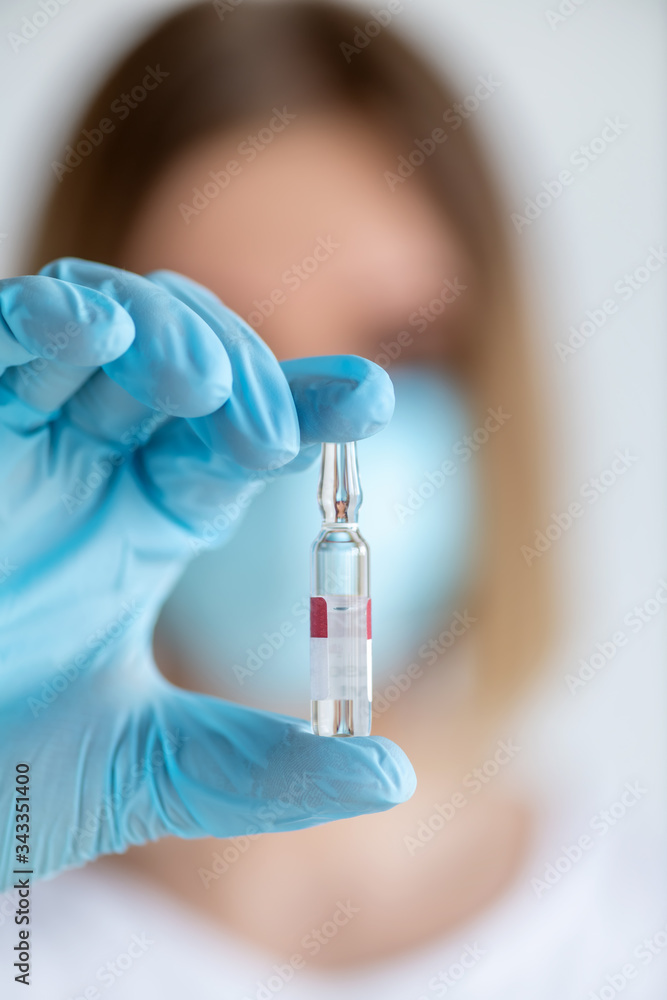 Medicine ampoule for injection in nurse hand. Medical glass vial for vaccination. Science equipment, liquid drug or vaccine Medicine ampoule for injection in nurse hand. Medical glass vial for vaccination. Science equipment, liquid drug or vaccine