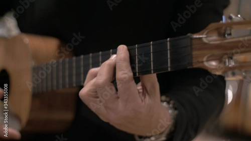 Another chords. String Cuatro instrument recording session, closeup, artist playing Venezuelan folk music with 4 strings, different chords / Cuatro, instrumento de cuatro cuerdas en sesin de grabación photo