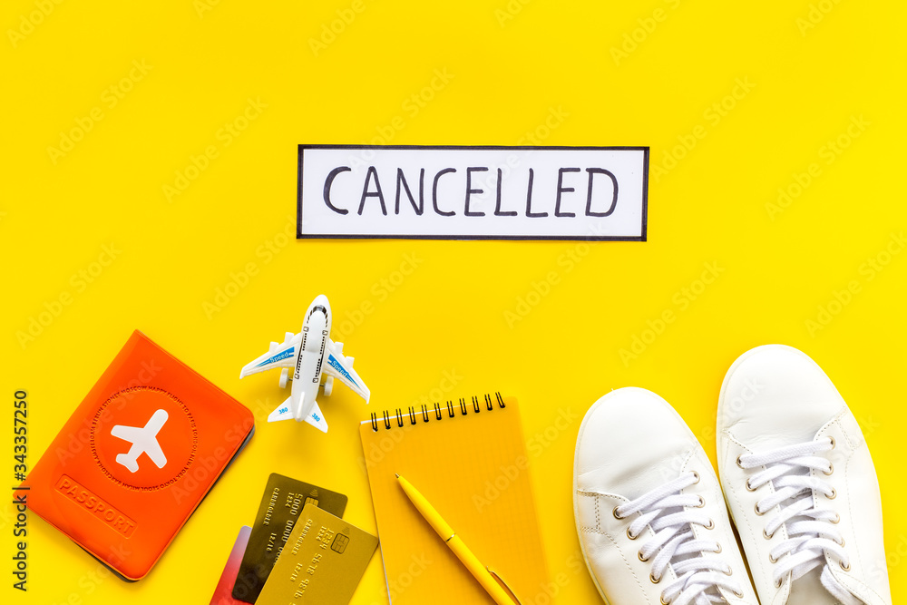 Cancelled flight. Airplane and passport on yellow background top view Cancelled flight. Airplane and passport on yellow background top view
