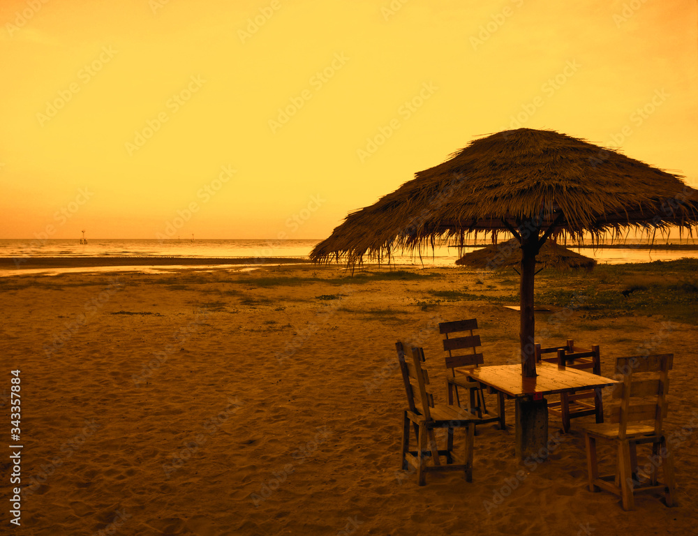 Sitting to eat under the coconut leaf visor at the beach in the evening