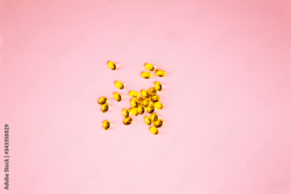 Vitamin d capsules on a pink background. Close up top view