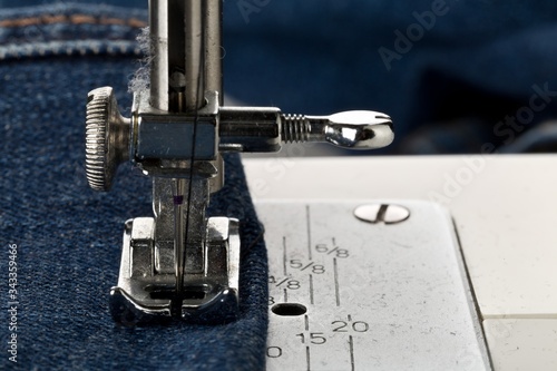 Fotografia, Obraz Blue jeans denim sewed on sewing machine close up - jeans fashion mending or rep