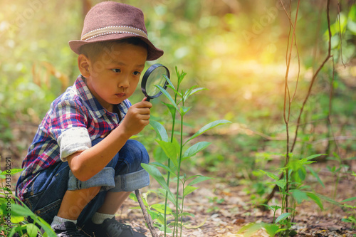 Happy little boy with magnifying glass explorer and learning the nature at home Fototapet