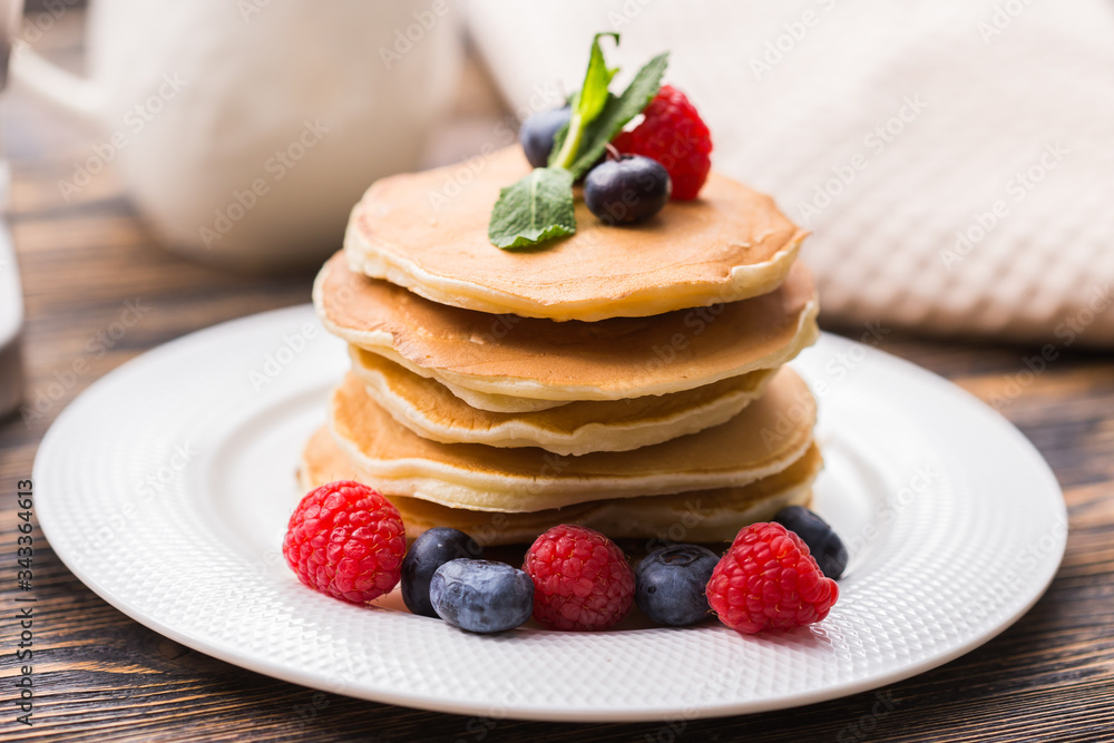 Homemade american pancakes with fresh blueberry and raspberries. Healthy morning breakfast. Rustic style Homemade american pancakes with fresh blueberry and raspberries. Healthy morning breakfast. Rustic style